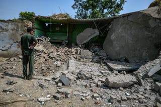 A villager stands outside a house damaged by overnight Pakistani artillery shelling in Kotmaira village near the Line of Control (LoC) in India's Jammu region